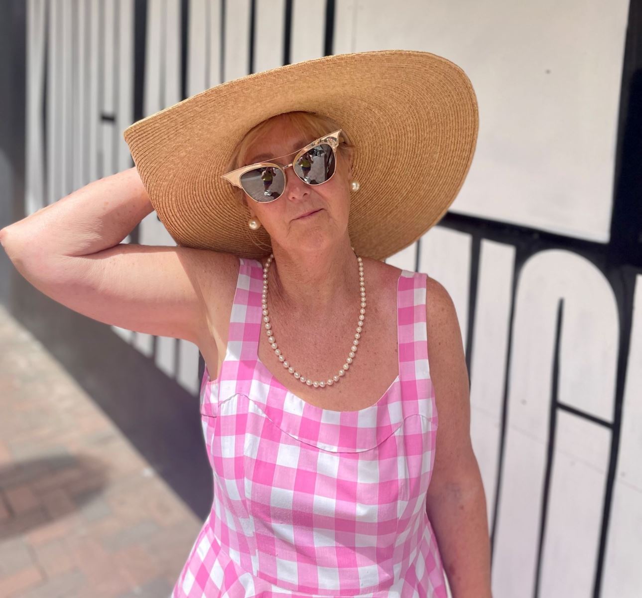 woman posing with her summer hat and pink dress outside kingland cresent in Poole 